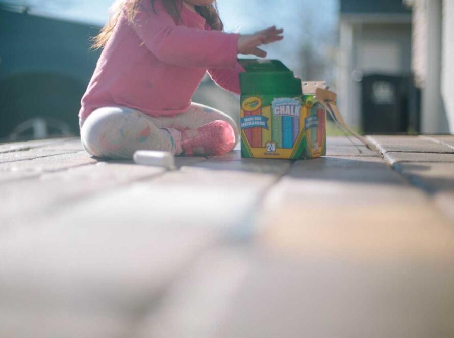 A little girl playing with a toy on the ground.