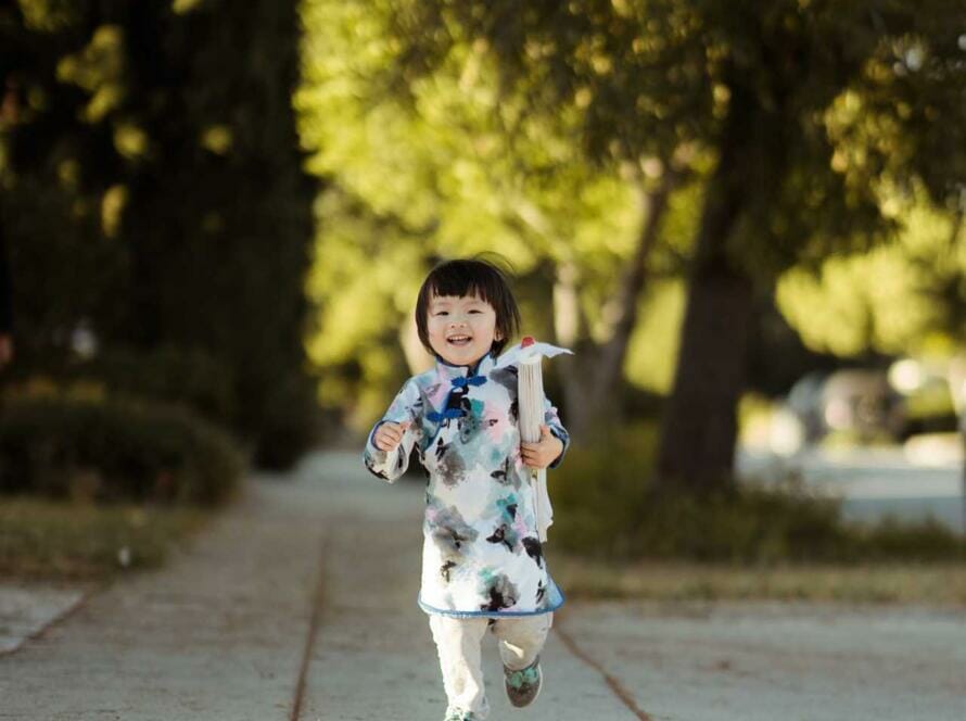 A little girl running down a sidewalk.