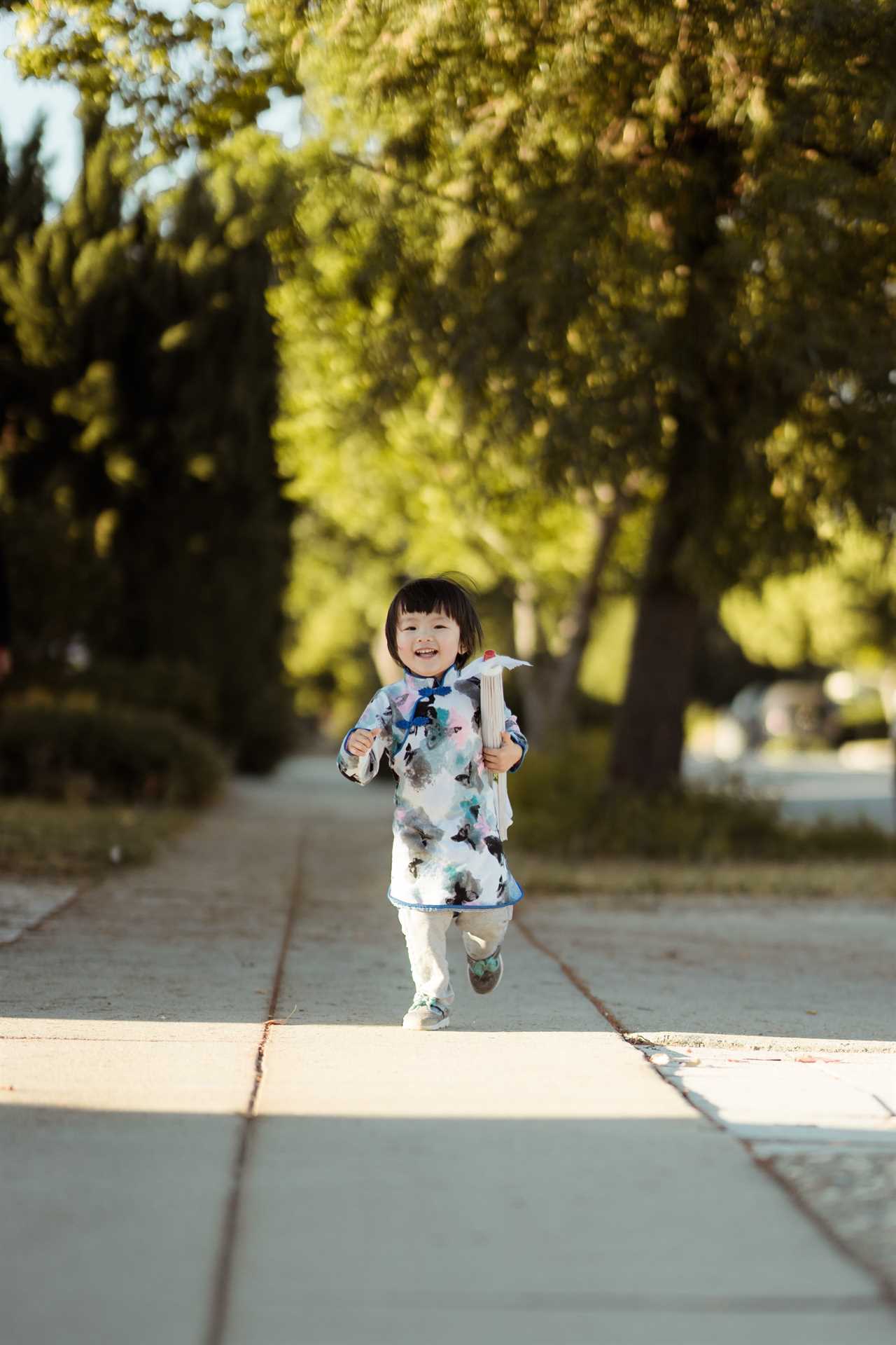 A little girl running down a sidewalk.