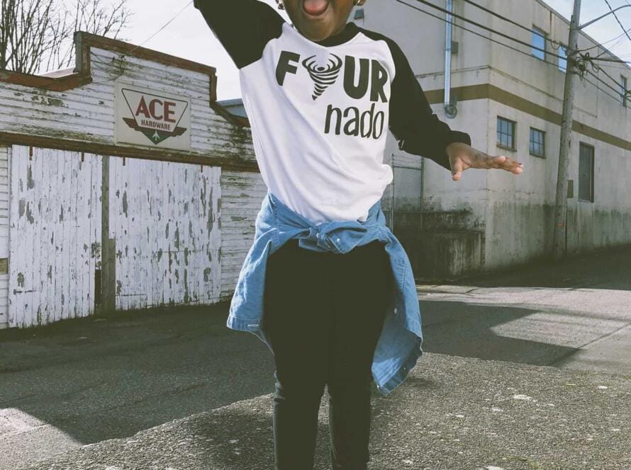 A little girl wearing a black and white raglan tee.