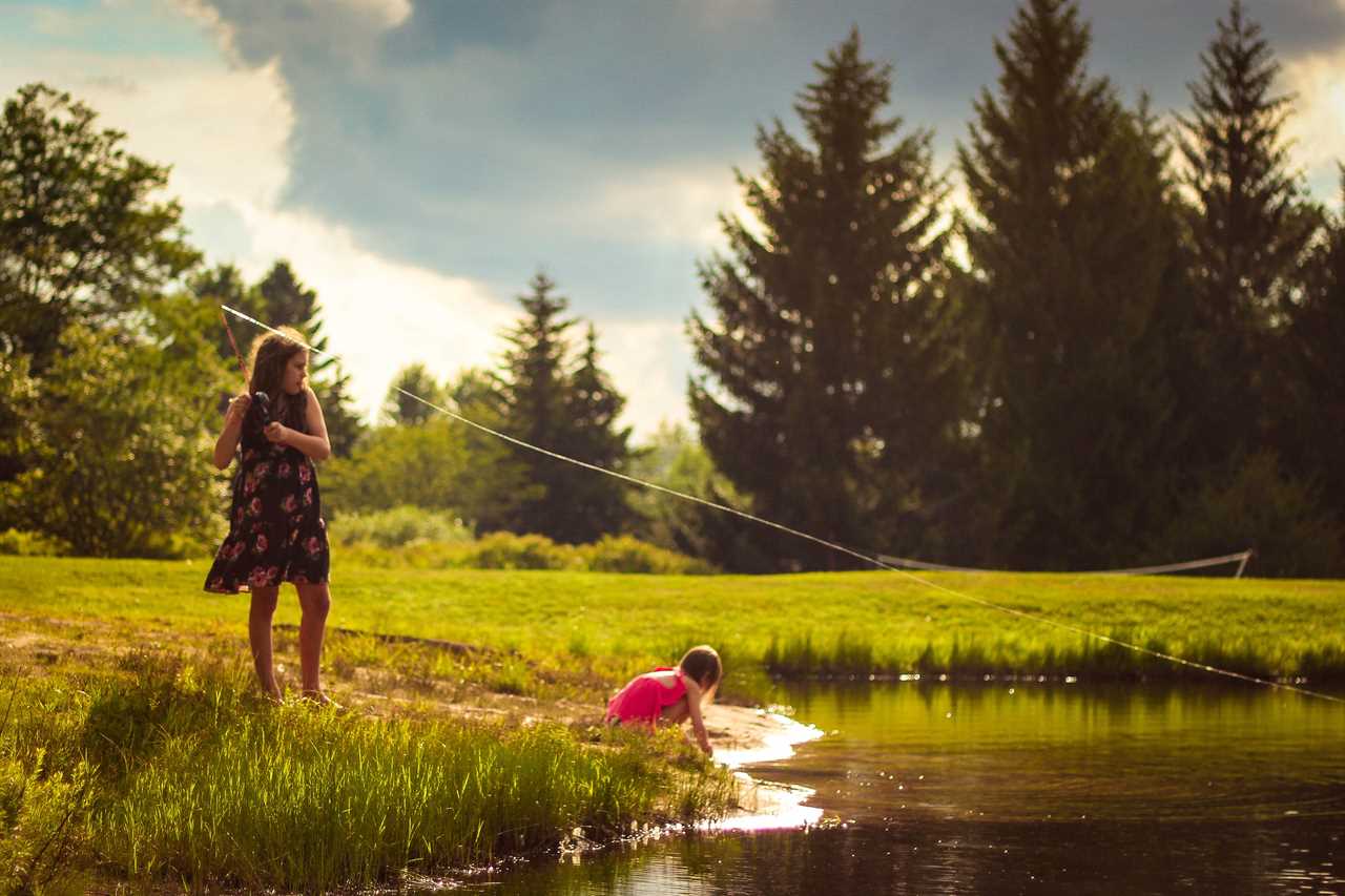 Two children fishing in a pond.