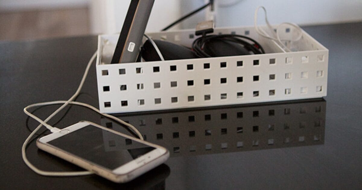 A cell phone is plugged into a charger on a table.