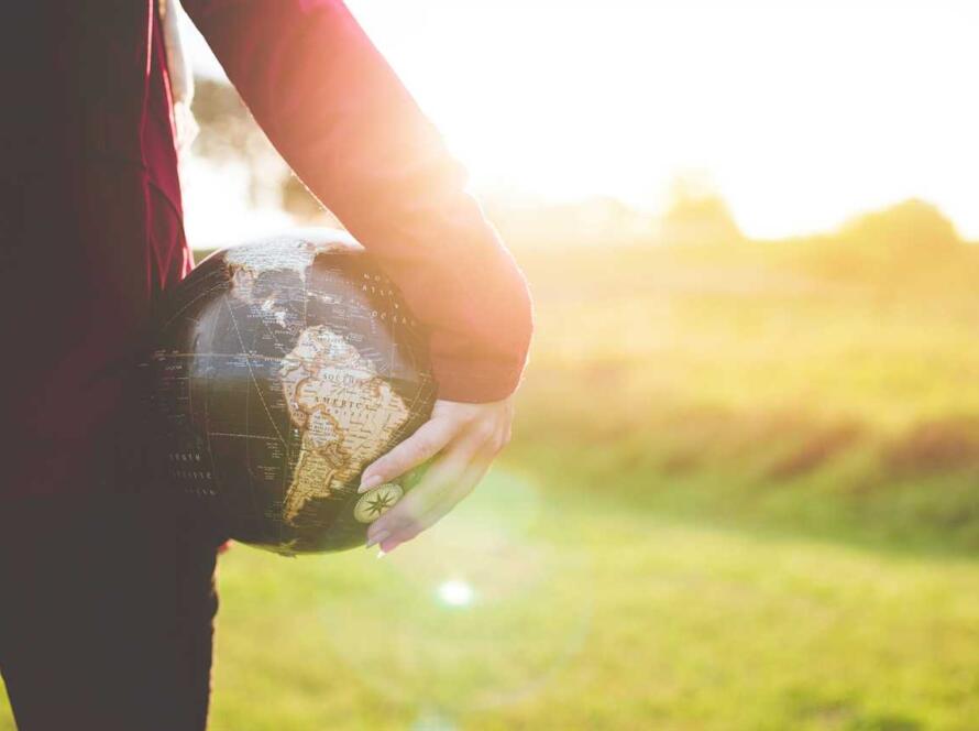 A woman holding a globe in her hands.