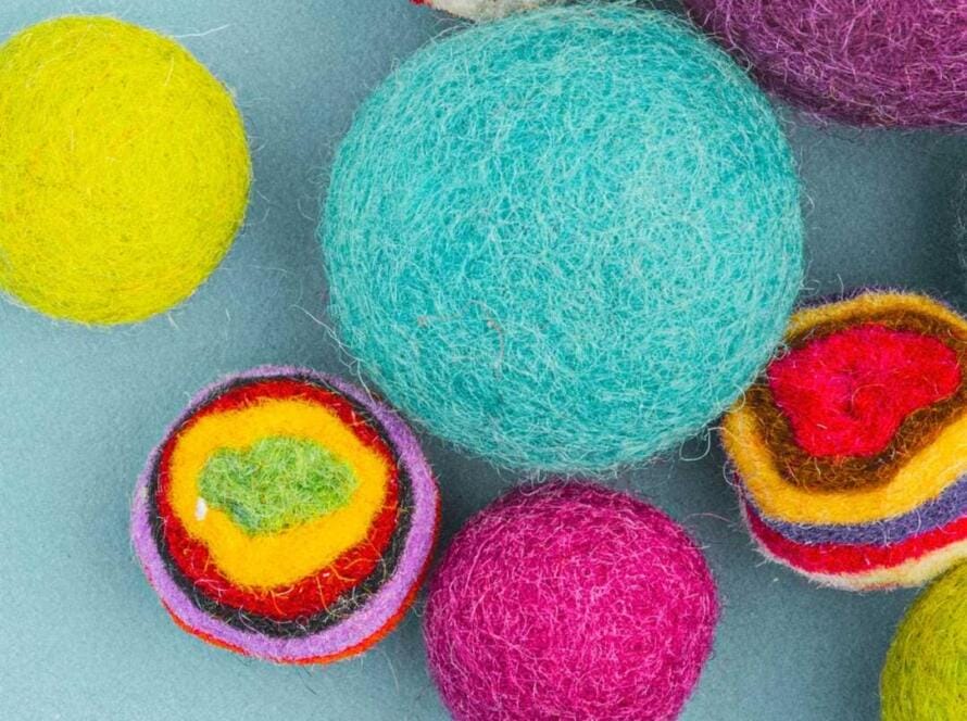 A group of colorful felt eggs on a blue surface.