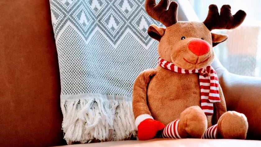 A stuffed reindeer sitting on a chair.