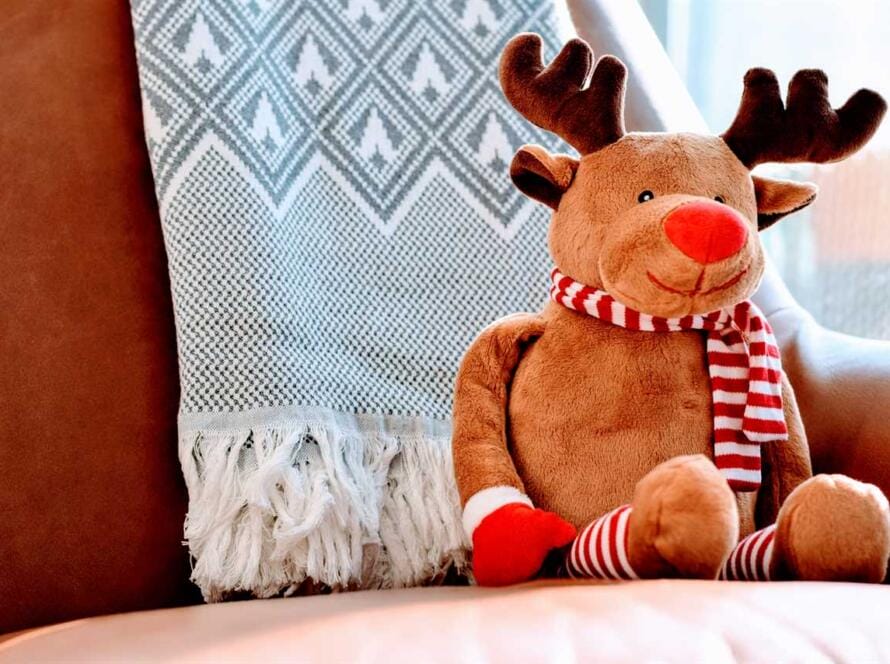 A stuffed reindeer sitting on a chair.