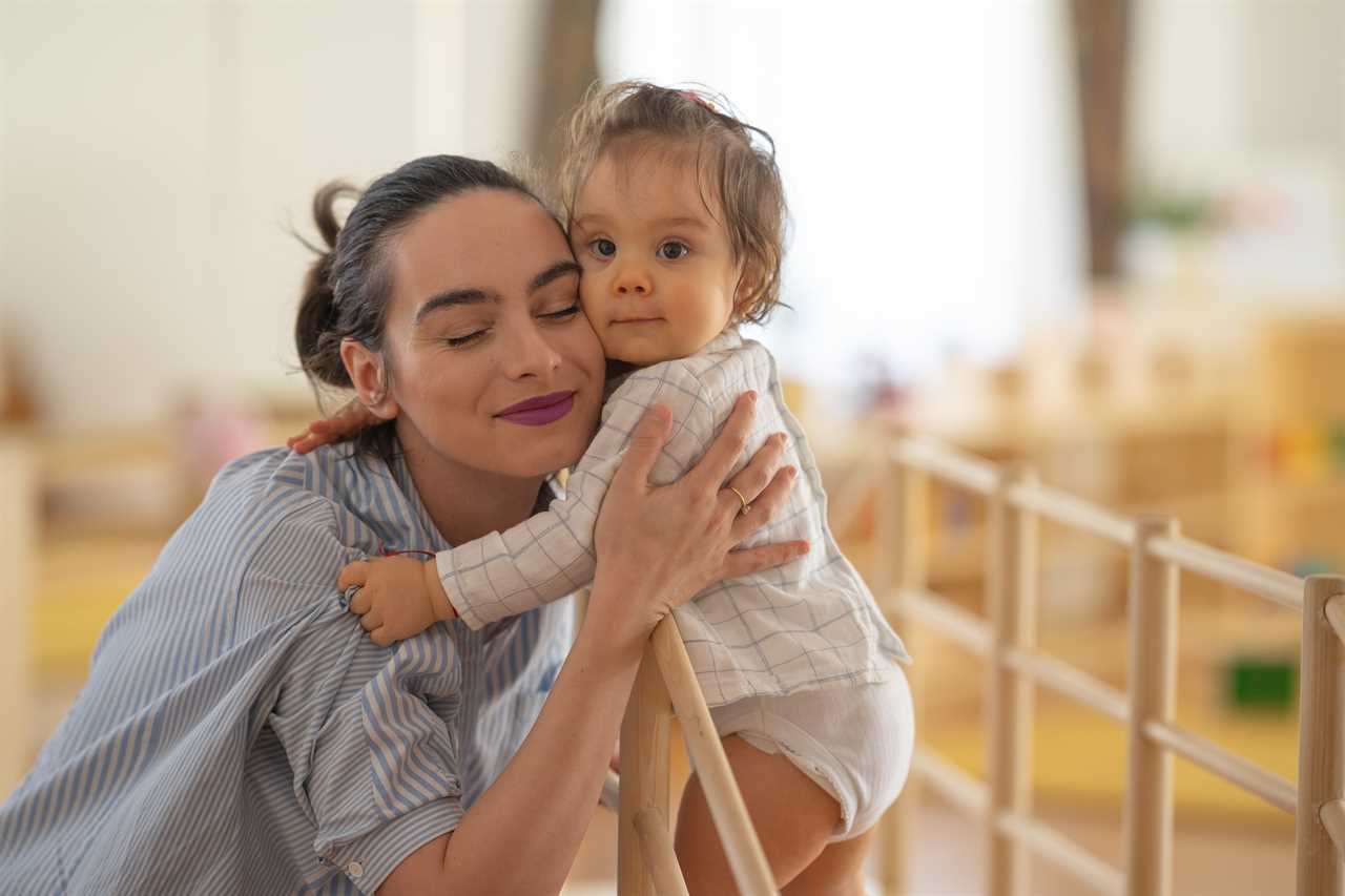 A woman is hugging a baby in a playroom.