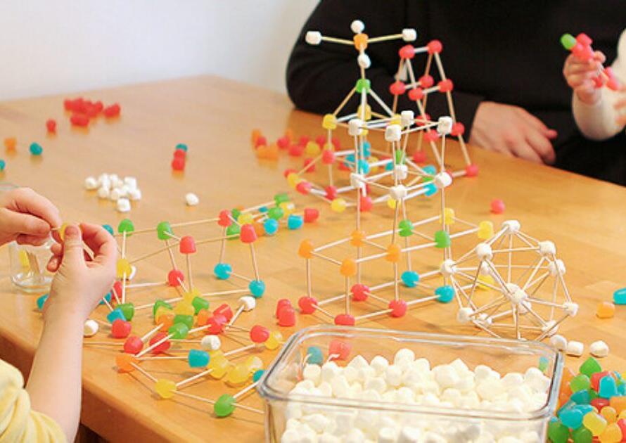 Children engaged in a stem activity, building molecular structures with colorful modelling kits.
