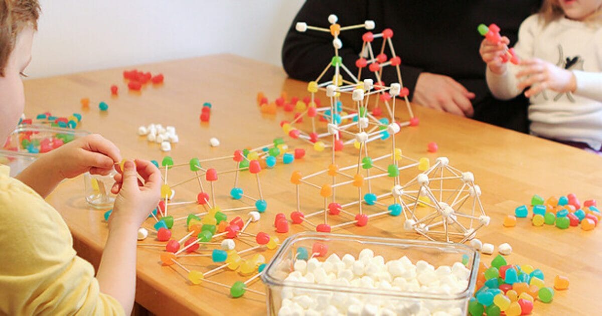 Children engaged in a stem activity, building molecular structures with colorful modelling kits.